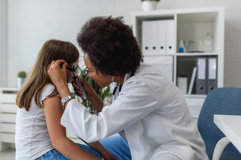The female doctor checking the ears of small child at Melbourne, FL