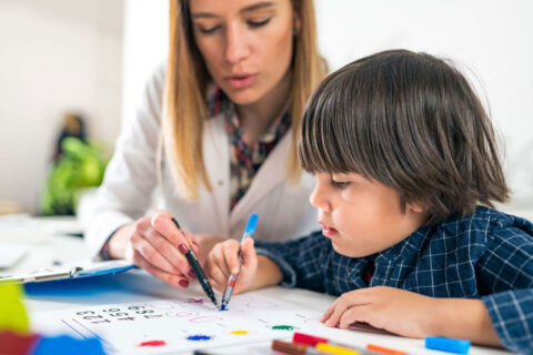 teacher teaching small boy