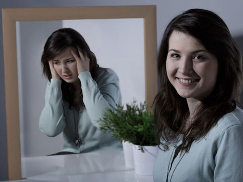 mirror and girl smiling and depressed on same time