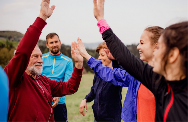 A group of adults in exercise clothing high-fiving