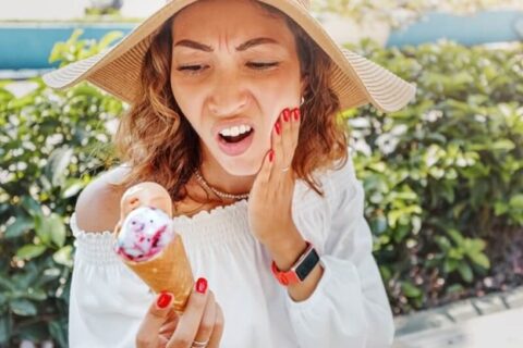 Woman facing tooth sensitivity while having an ice cream