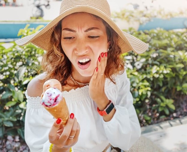 Woman facing tooth sensitivity while having an ice cream