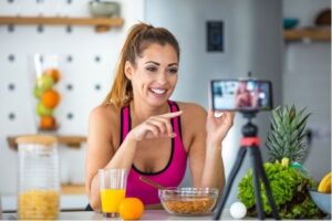 Woman in workout clothing filming a social media video