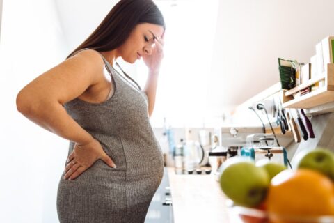 Pregnant woman facing back pain - Brevard Health Alliance