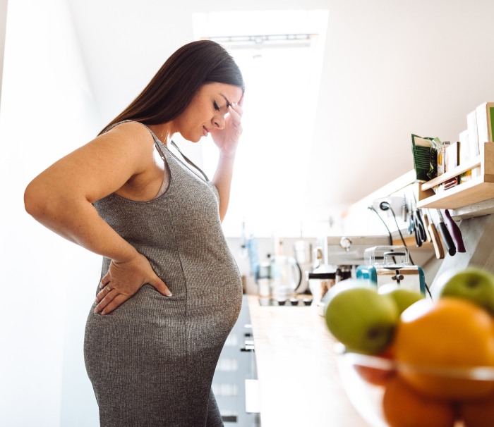 Pregnant woman facing back pain - Brevard Health Alliance